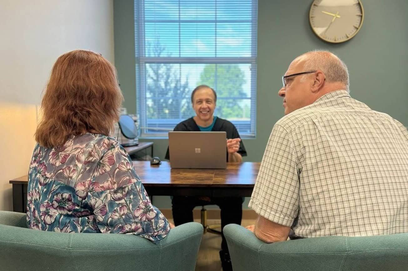 A couple in consultation with Dr. Sanders across the desk