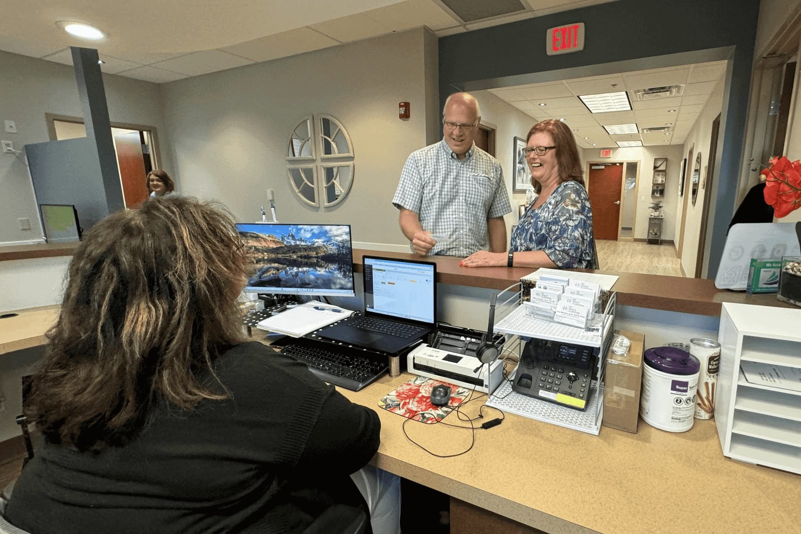 A patient at the front desk with the team